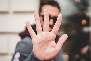 Man holding up five fingers