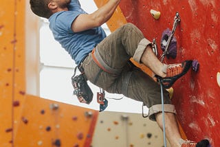 A man rock climbing to the top.