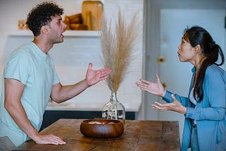 A couple arguing in the kitchen.