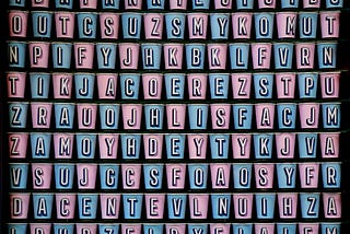 Letters of the alphabet written on pink and blue cups