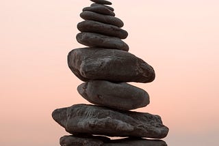 A pile of perfectly balanced rocks stands against the sky.