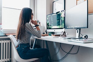 Front end developer coding in front of their computer with two monitors