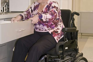 Woman in a wheelchair dressed for work at an office.