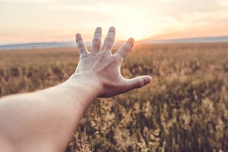 Hand reaching out at the horizon