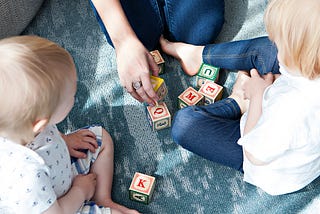 Mom playing blocks with two small children