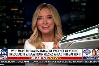 Kayleigh McEnany wears a white shirt & holds white binders whitely on Fox News