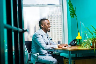 A man sitting on a chair and smiling.