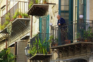 Picture of an old guy standing on his balcony via Alt text on Medium