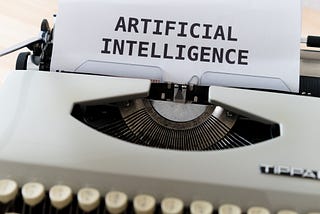 A photo of a typewriter with paper inserted that reads: Artificial Intelligence.