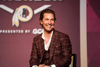 Image of Matthew McConaughey seated on stage at an event.