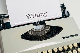 Typewriter with a page labeled “Writing”