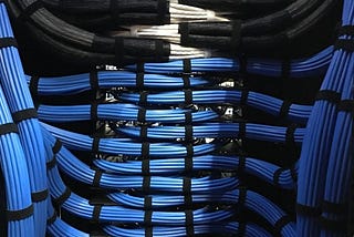 Hundreds of blue data cables, properly bundled with cable straps in a data center server rack