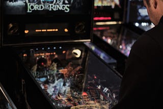 man playing a pinball machine