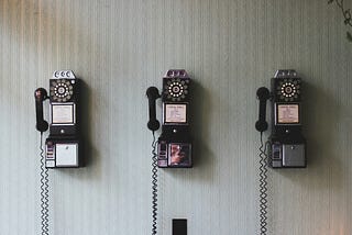 Three dial and handpiece telephones on a wall