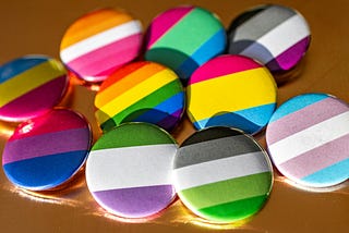 A photo of colorful LGBTQIA+ wearable buttons.