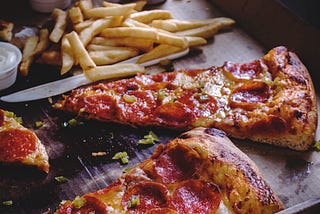 “A piping hot slice of Hawaiian Pizza on a plate, topped with tomato sauce, melted mozzarella cheese, ham slices, and juicy pineapple chunks.”