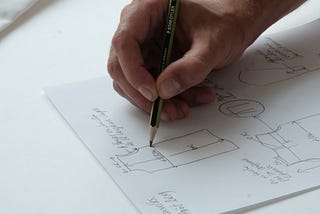 A designer sketching a drawing on paper.