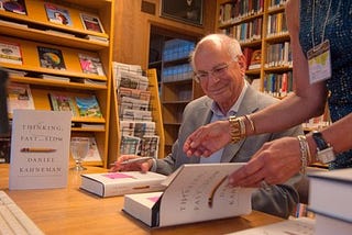 Daniel Kahneman signing copies of “Thinking, Fast and Slow” in CASBS’s library reading room in 2013. [CASBS files]