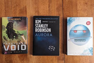 Tim Pratt’s “The Fractured Void” (2020), Kim Stanley Robinson’s “Aurora” (2015), and Douglas Adams’ “Hitchhiker’s Guide to the Galaxy” (1979)