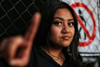 Woman holds up a hand in a “stop” gesture