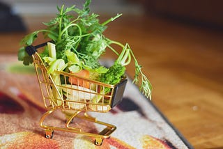 Tiny shopping cart filled with bits and pieces of vegetables.