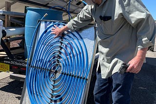 Hill Kemp, co-founder and CTO of ener.com showing the PV Cooling module in Taos, NM last week. This module is installed behind new or existing PV panels in order to increase their performance and life.