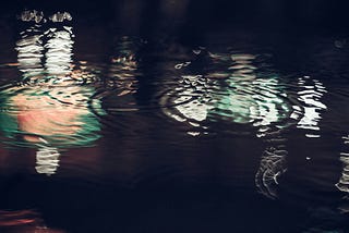 raindrops in a pool of water at night