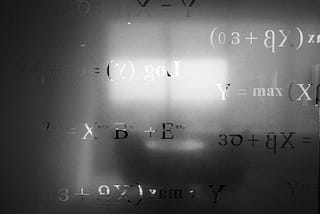 Equations inscribed in frosted glass, with a blurred image behind