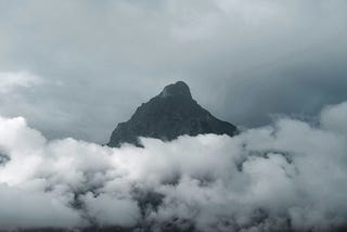 A mountain peak surrounded by thick white clouds