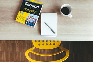table and chair showing someone about to study with a german for dummies guidebook.