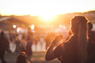 Looking into the bright sun into a blurry crowd