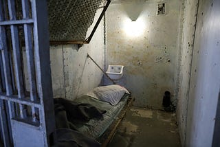 A tiny, grungy and cramped prison cell.