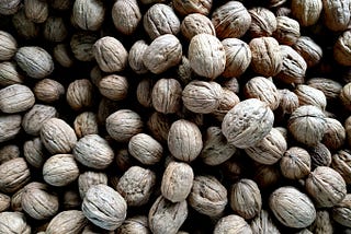 A pile of unshelled walnuts.