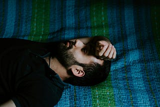 A man lying on the bed, thinking.