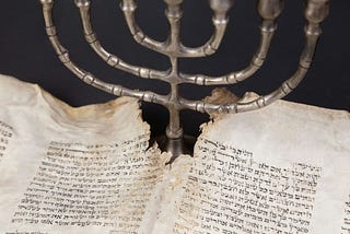 A menorah with an ancient manuscript.