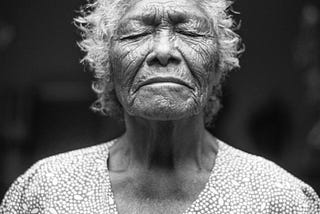 An elderlywoman closes her eyes