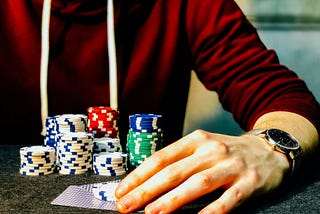 Young man playing poker with stacks of colored chips
