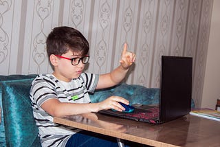 Young boy starting programming on a laptop