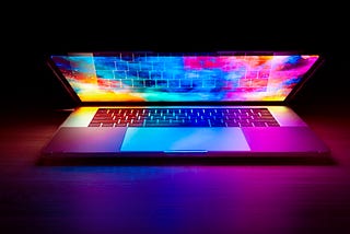 partially open laptop bathed in glowing colors