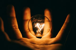 a lightbulb suspended in a hand