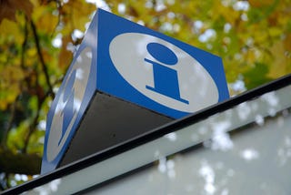 A blue information sign, with leaves in the background