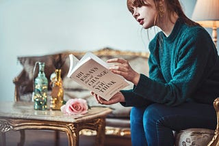 A women reads a book while sitting in the sopha