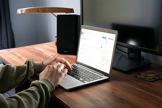 A person writing a blog post on a laptop computer.