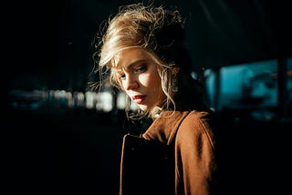 A woman looking at something on the floor with disappointment