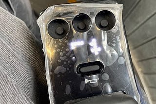 Picture of a Whill CI Model 2 wheelchair joystick with the protective plastic still attached. The LED display, which is supposed to show the amount of battery remaining and speed, has 1/3 of the pixels blacked out and non-functional. The button panel has been ripped out because the hard plastic top was peeled back, which requires significant force.