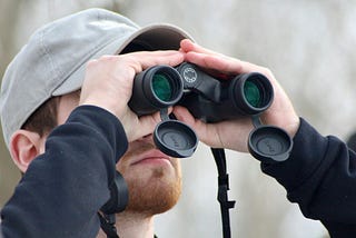 Man staring through binoculars.
