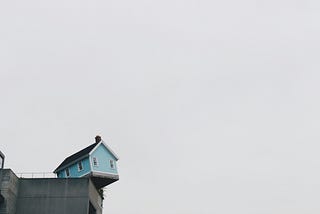 A blue concrete storey house on top of building at daytime