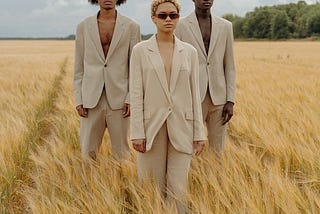 Three models standing in lush hay-field