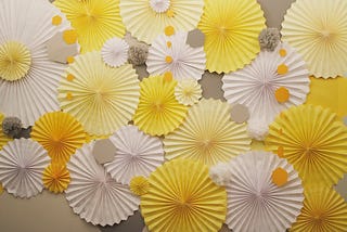 a display of accordion fold paper flowers (or possibly the tops of umbrellas) in shades of yellow