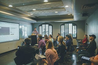 People in a classroom staring at a powerpoint picture